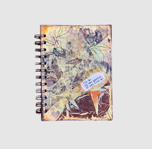 Medium nature-inspired handmade journal cover in browns, oranges and greens  with 'I'll be in the garden if you need me' on the front.