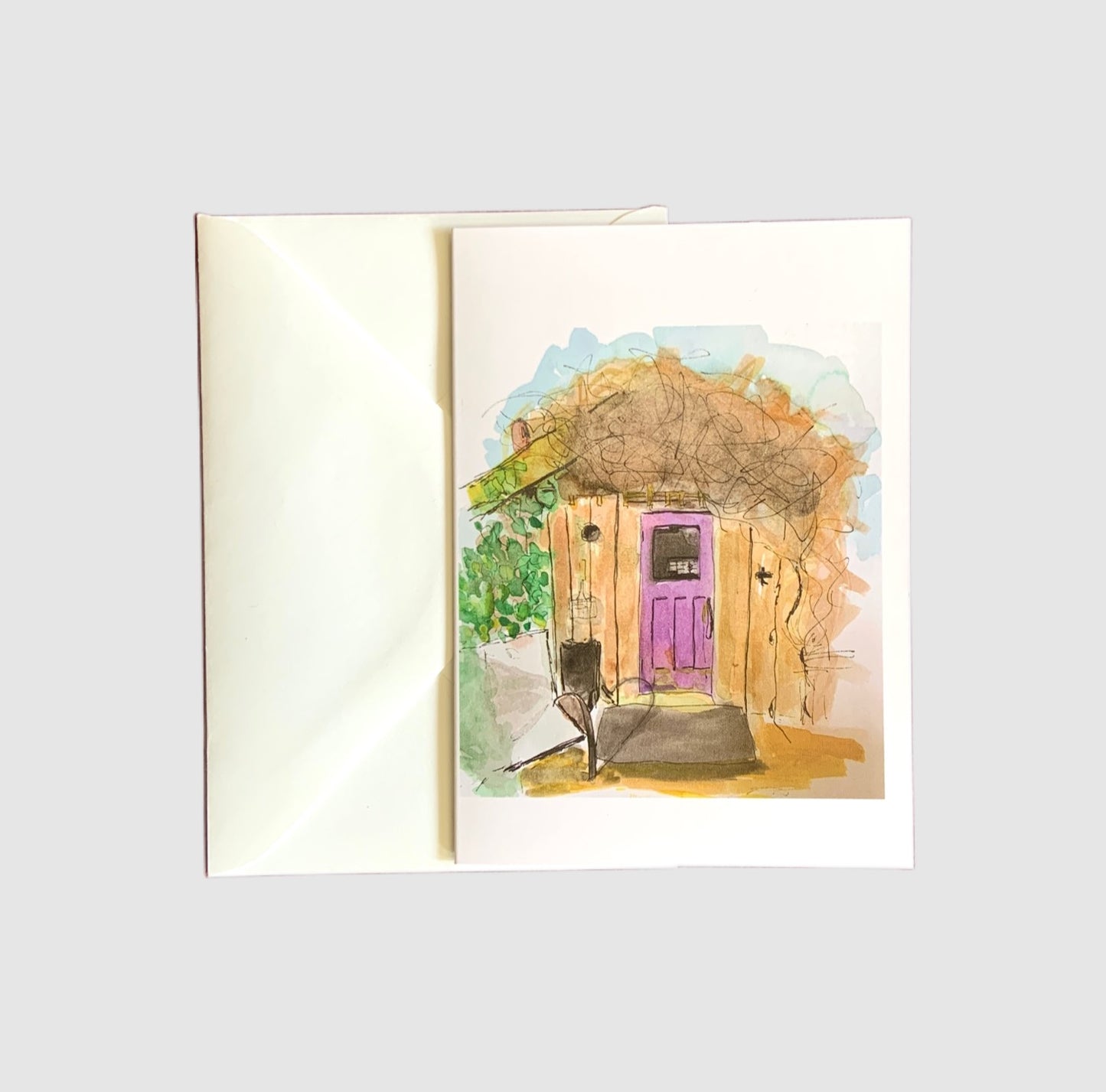 A sketch of a rustic shed covered in a honeysuckle vine painted with watercolors on the front of a greeting card.