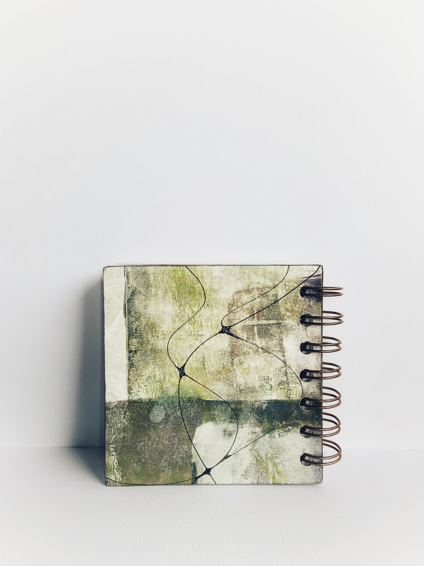 Back page of handmade mini hardcover journal painted in greens and greys with fine black neurographic lines