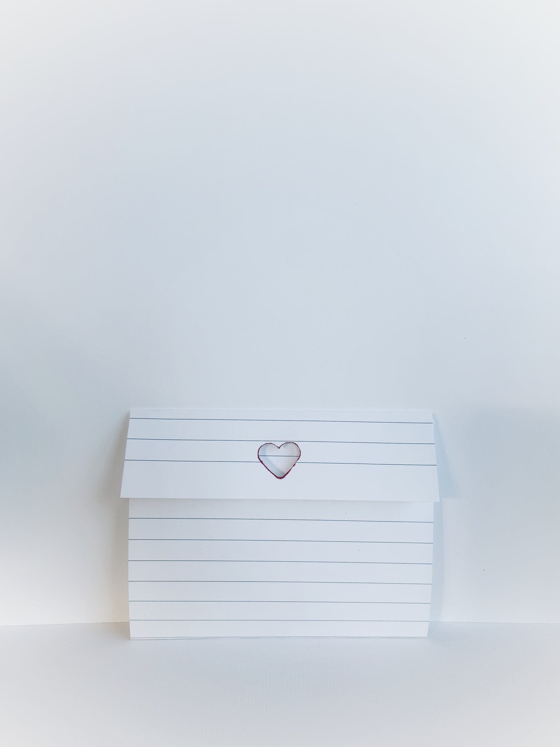 Folded lined notepaper with a cutout heart.