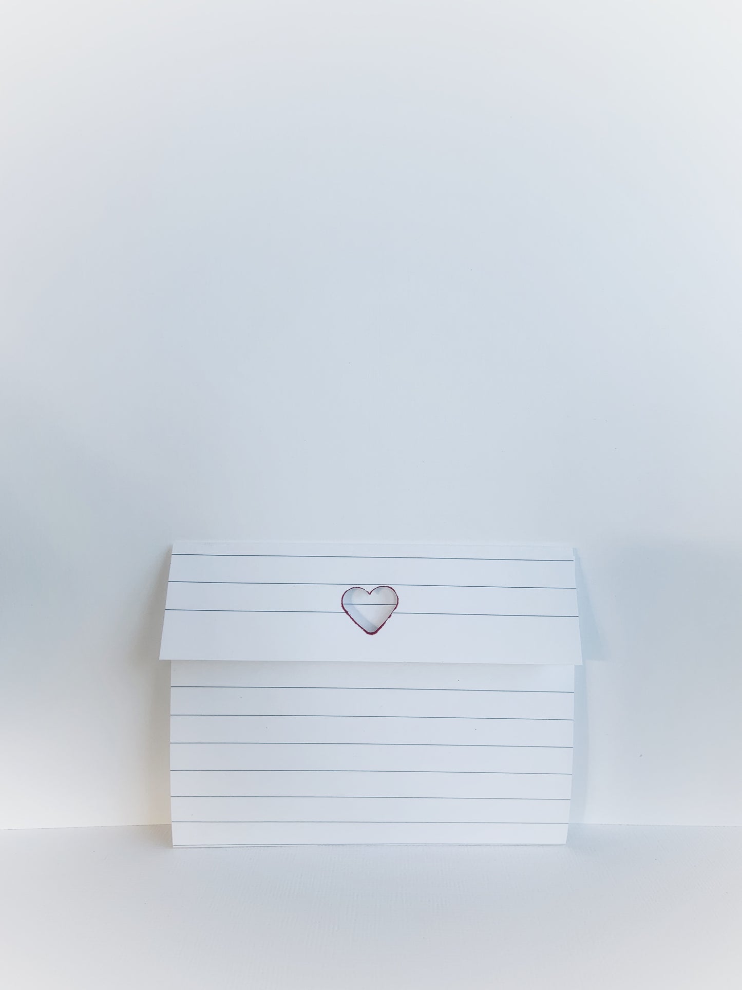 Folded lined notepaper with a cutout heart.