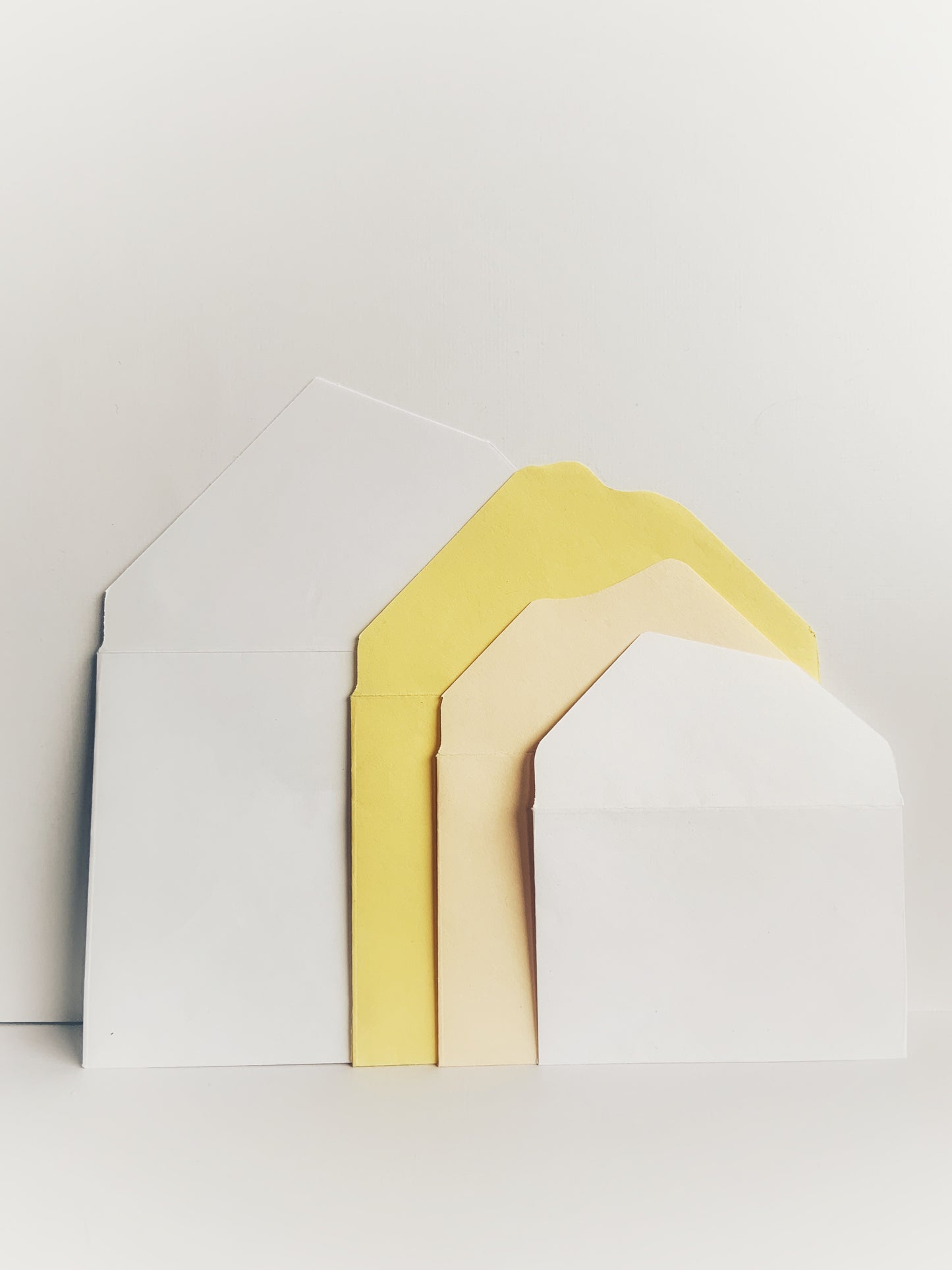 Handmade nesting envelopes in plain white and yellow showing custom flaps