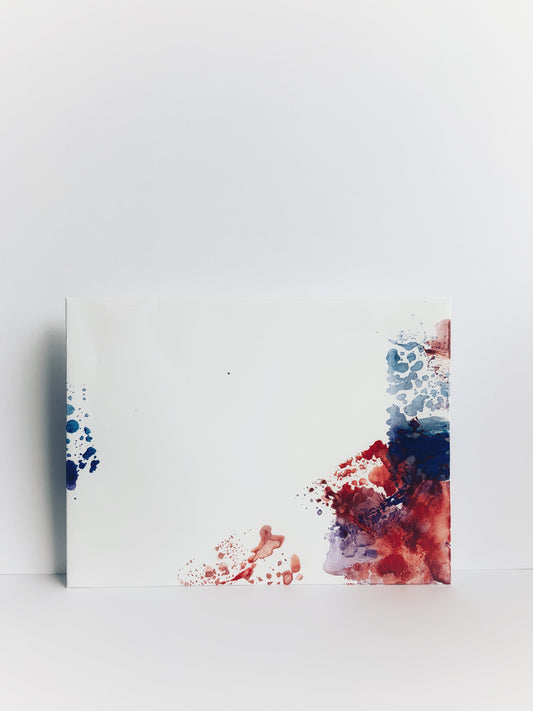The front of a handmade envelope painted in blue and red watercolor