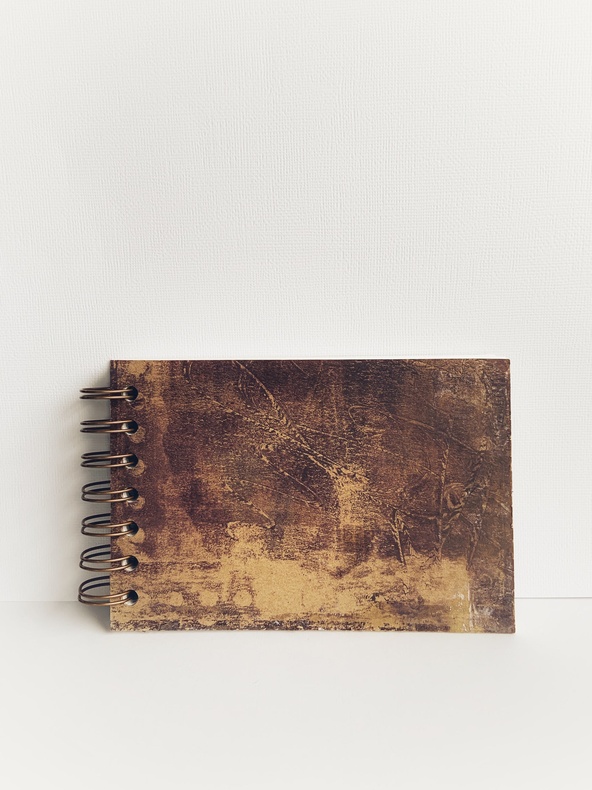 Front cover of a handmade journal in shades of brown that gives it a leather look