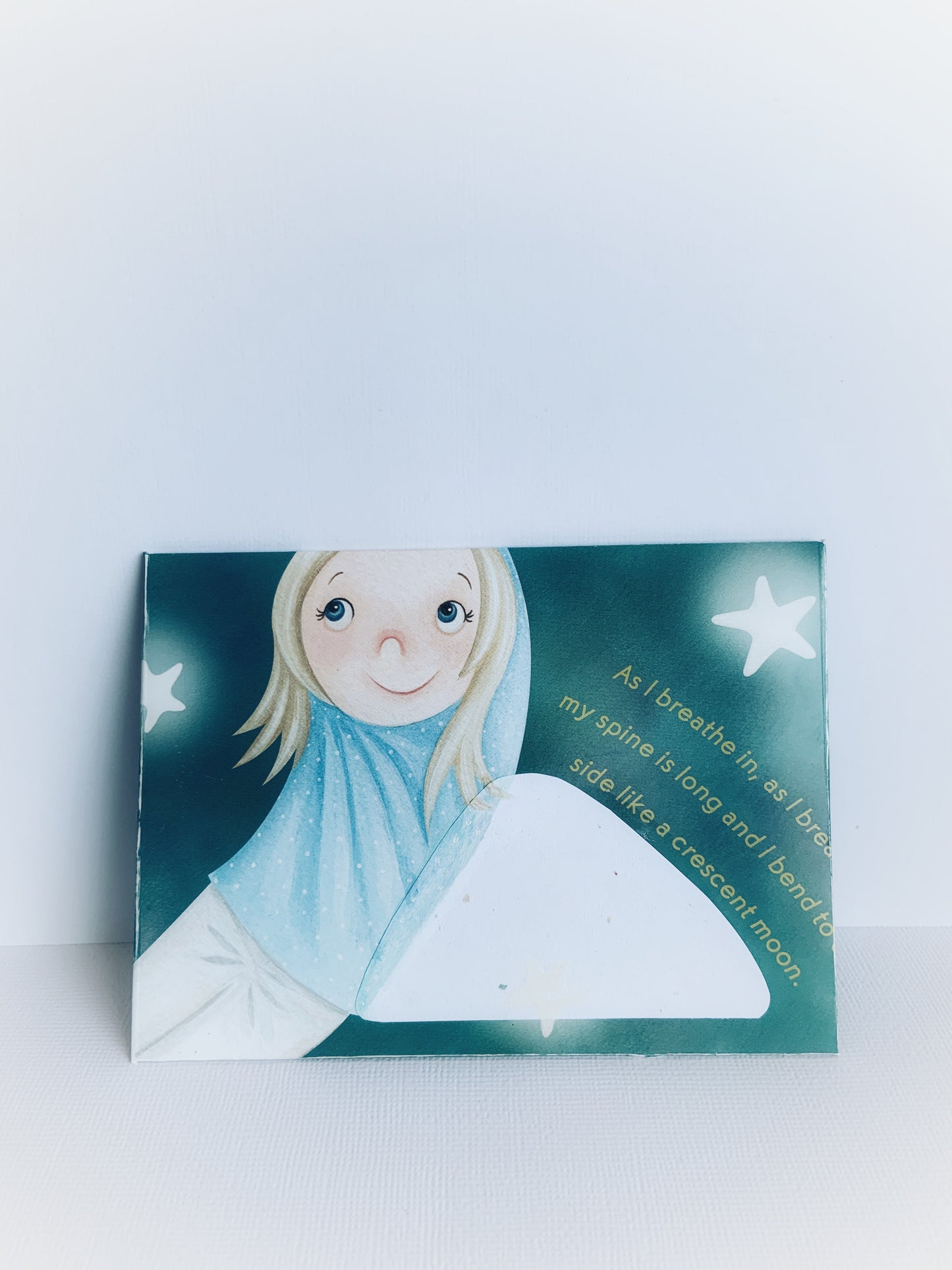 The front of a children's handmade envelope with a little girl with her arms up bending to the side and stars around her.